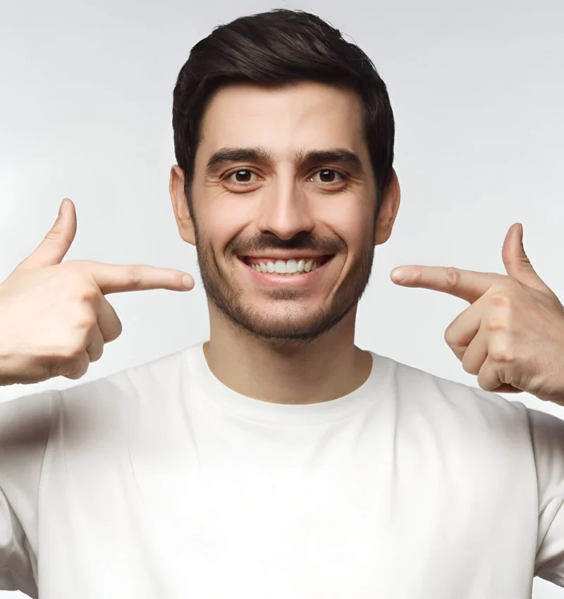 portrait-smiling-young-man-pointing-his-perfect-natural-white-teeth-after-whitening-treatment-dental-clinic-ads-concept-ezgif.com-optiwebp